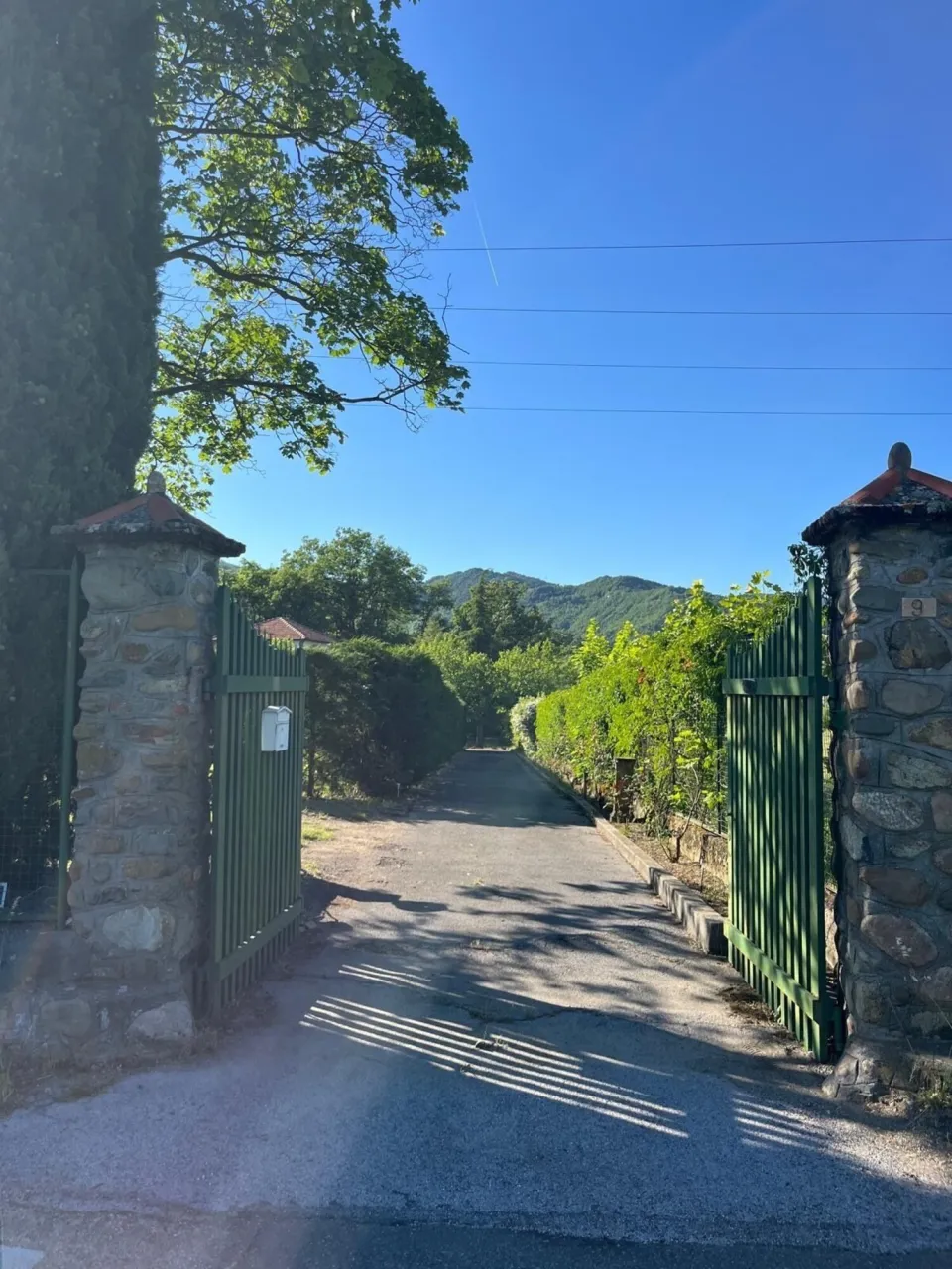 Stone gateway marked '9' leading onto the property road