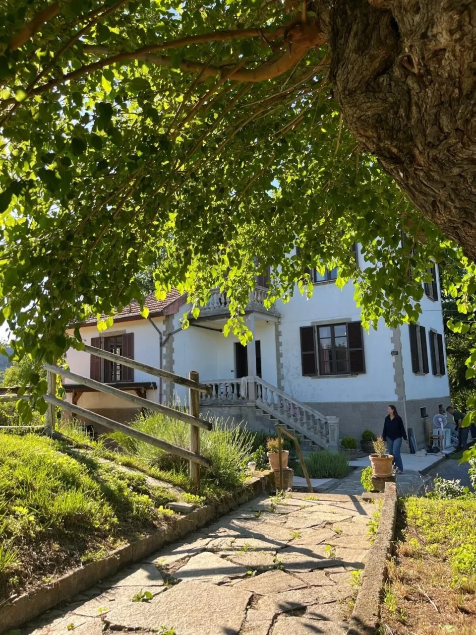 Rustic house with a stone path leading to a wooden staircase