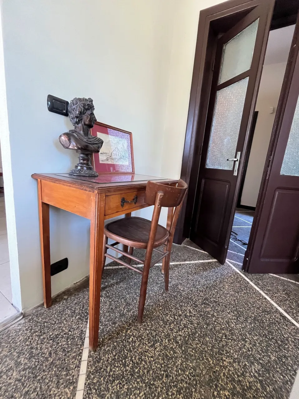 Wooden desk with a bust and a door with etched glass panels