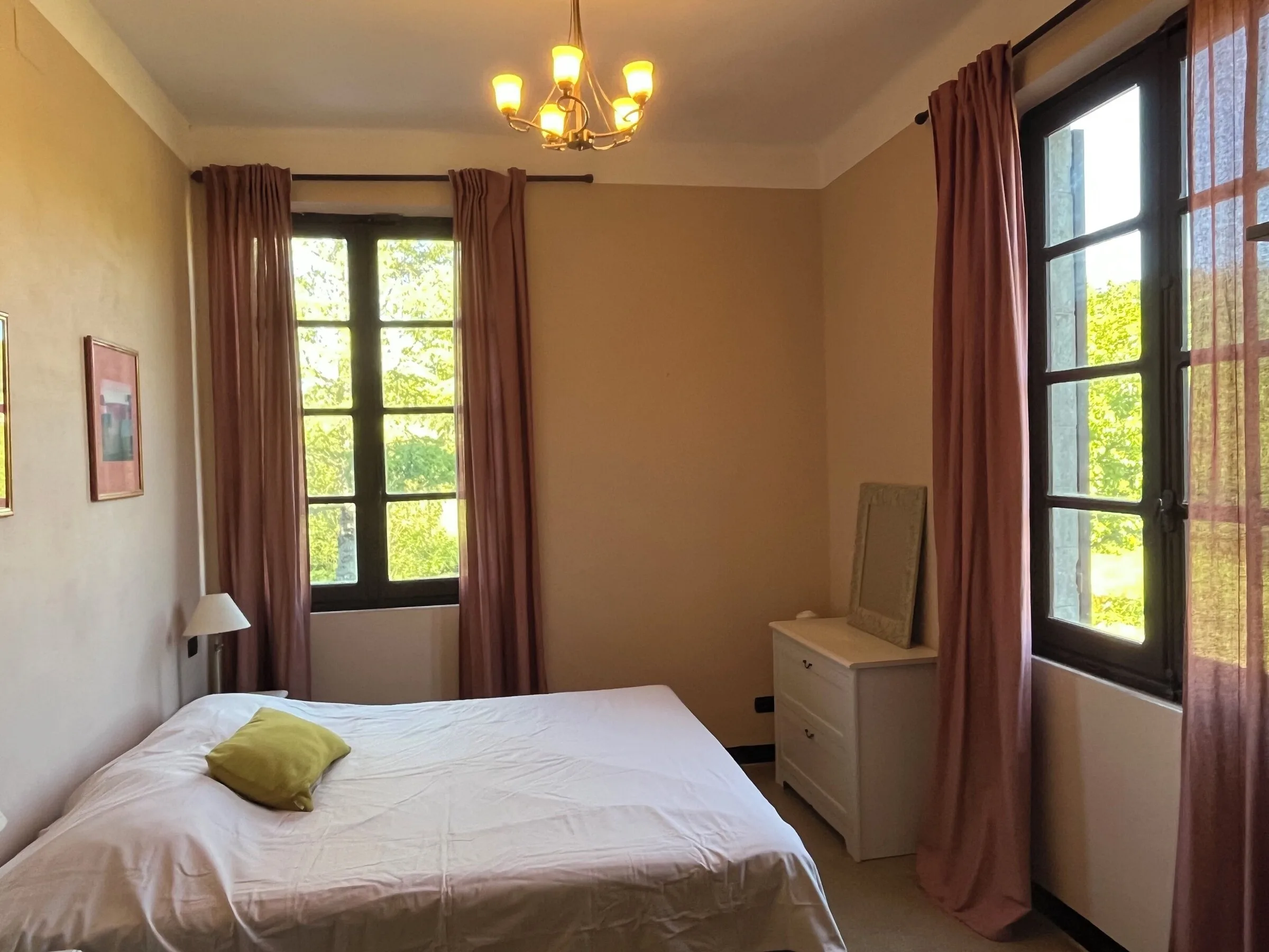 Bedroom with a chandelier and large windows