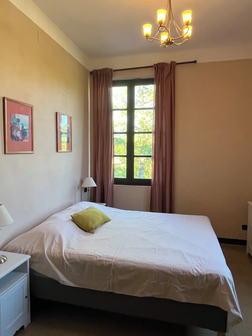 Bedroom with a bed, nightstand and framed photos