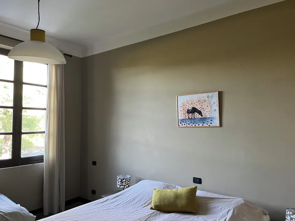 Bedroom with a bed, framed artwork and a bedside lamp