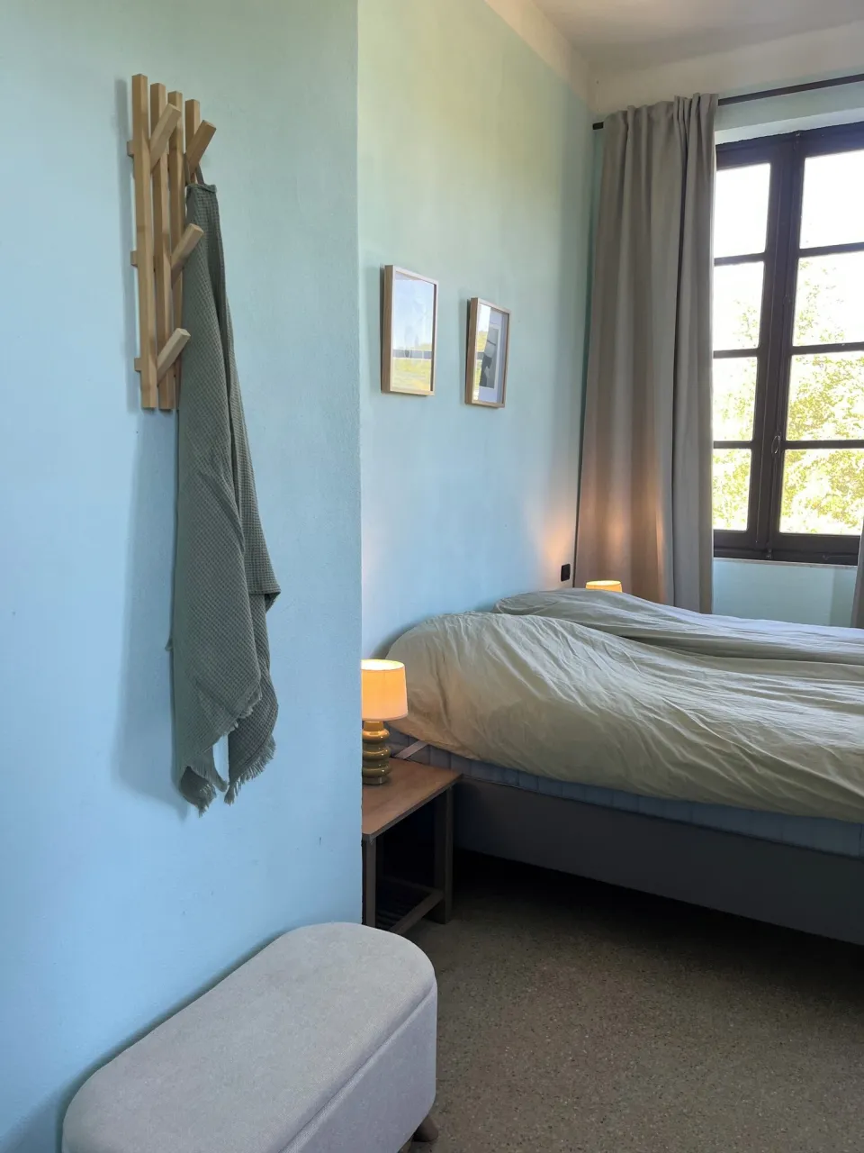 Bedroom with a bed, bench and framed photos