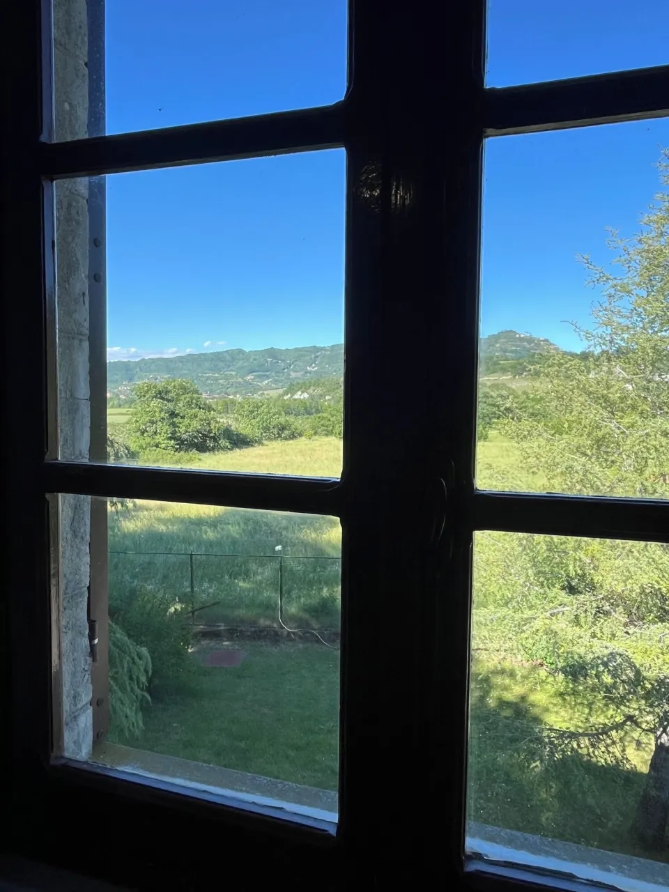 Window with a view over the green landscape and hills