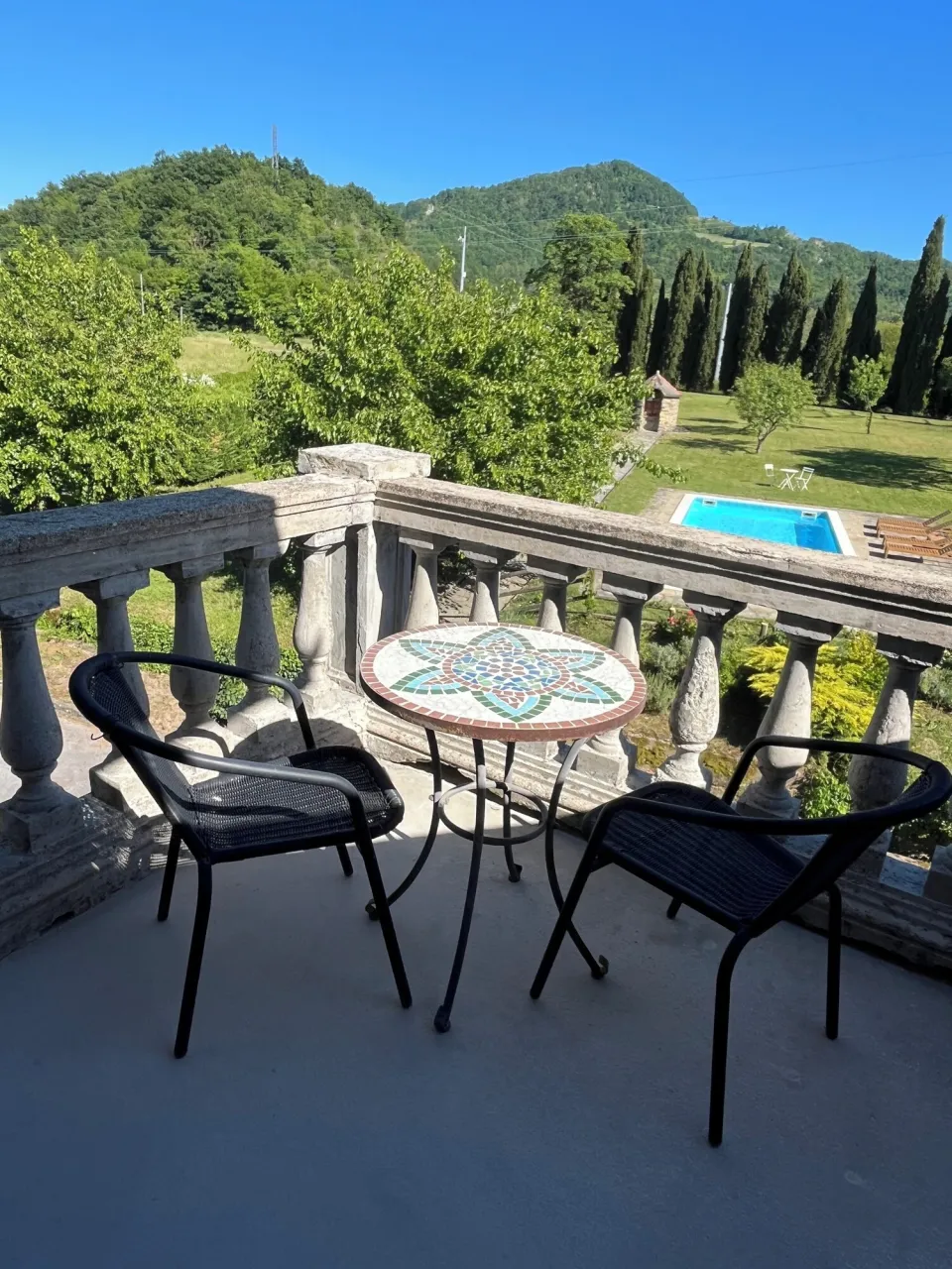 Balcony with a view over the pool and hills